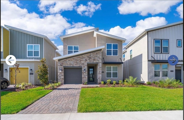 view of front of home with a front lawn, stucco siding, decorative driveway, stone siding, and an attached garage