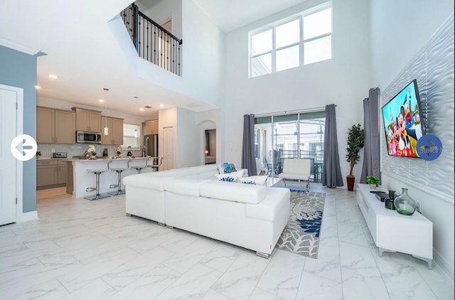 living area with recessed lighting and marble finish floor