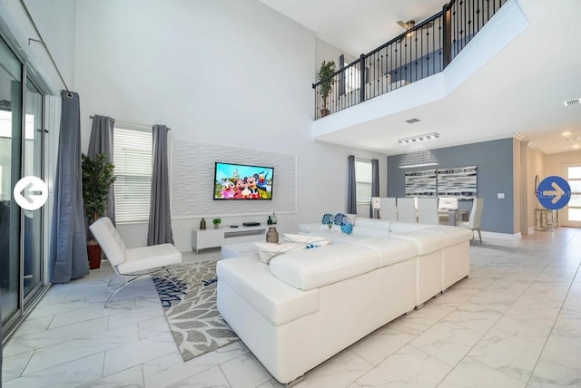 living area with baseboards, marble finish floor, and a towering ceiling