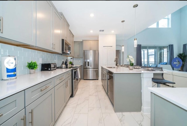 kitchen with backsplash, stainless steel appliances, marble finish floor, and gray cabinetry