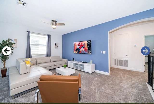 living room with visible vents, arched walkways, a ceiling fan, and carpet flooring