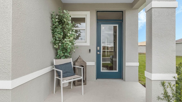 view of exterior entry featuring stucco siding