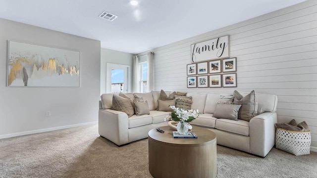 living room featuring light colored carpet, visible vents, and baseboards