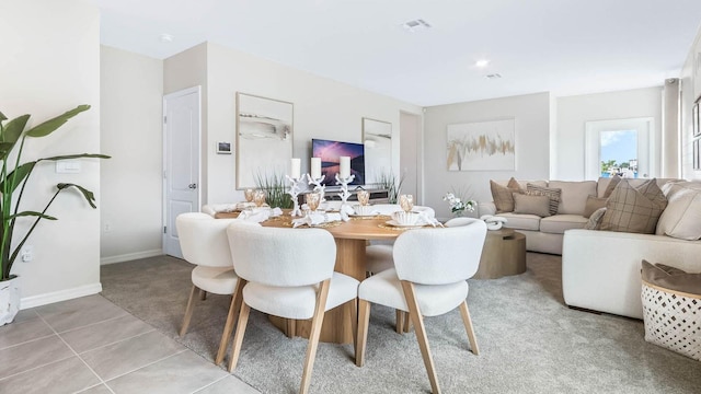 living area featuring light tile patterned floors, visible vents, and baseboards