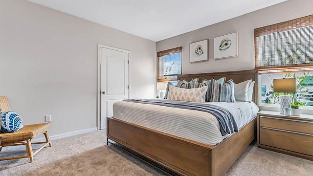 bedroom with light carpet and baseboards