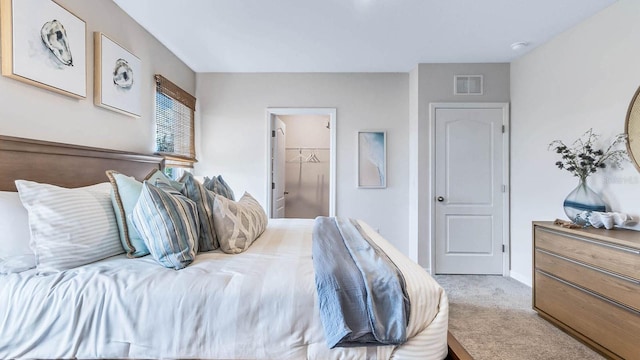 bedroom featuring visible vents, carpet, and a walk in closet