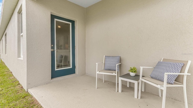 entrance to property with stucco siding and a patio area