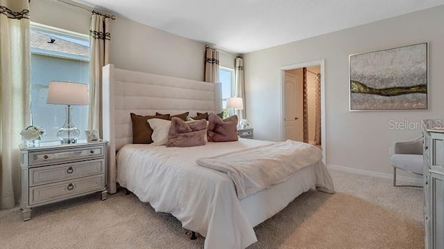 bedroom featuring light colored carpet and baseboards