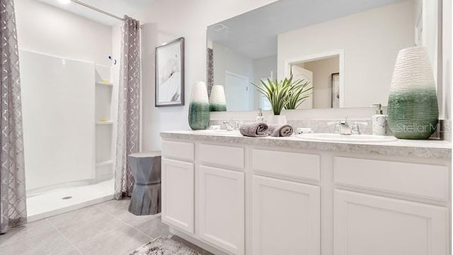 bathroom with tile patterned flooring, double vanity, curtained shower, and a sink