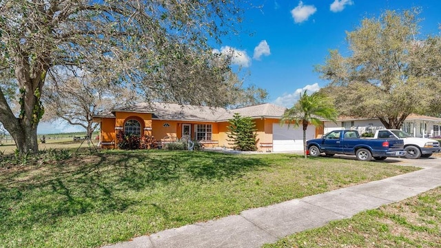 ranch-style home featuring a front yard, an attached garage, and stucco siding