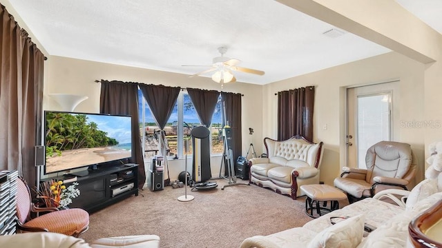 carpeted living area featuring visible vents and a ceiling fan