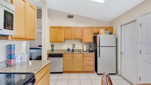 kitchen featuring visible vents, a sink, white appliances, light tile patterned floors, and lofted ceiling