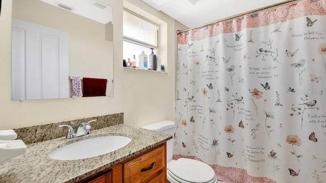 bathroom featuring visible vents, toilet, vanity, and a shower with curtain