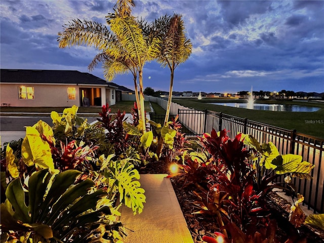 exterior space featuring fence and a water view