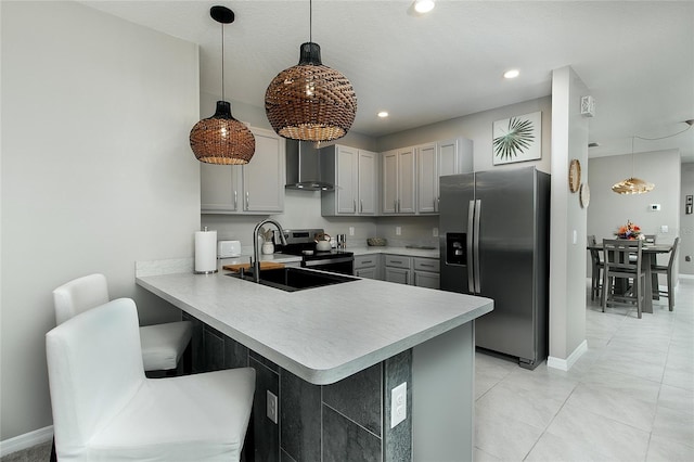 kitchen featuring gray cabinetry, a sink, appliances with stainless steel finishes, a peninsula, and light countertops