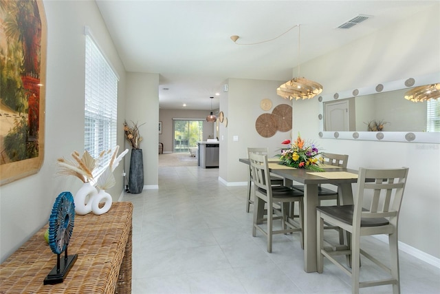 dining area with light tile patterned flooring, visible vents, and baseboards