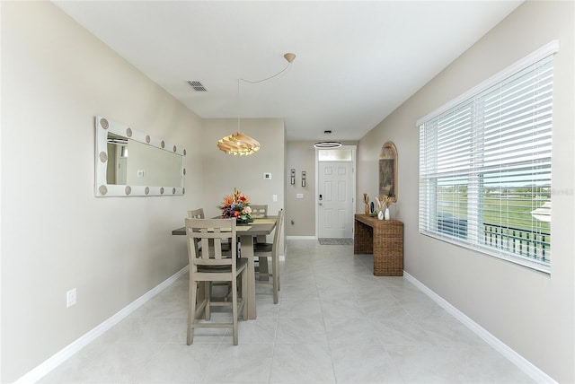 dining room with light tile patterned floors, visible vents, and baseboards