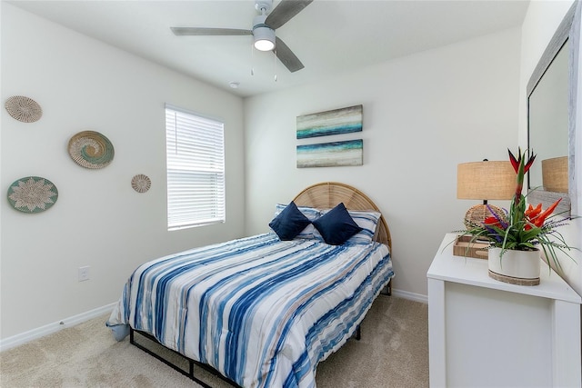 bedroom featuring light carpet, a ceiling fan, and baseboards