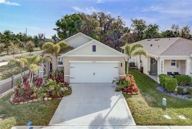 ranch-style house featuring fence, concrete driveway, a front yard, stucco siding, and a garage