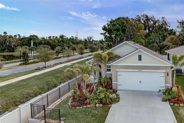 view of front of property with a front yard, an attached garage, fence, and driveway