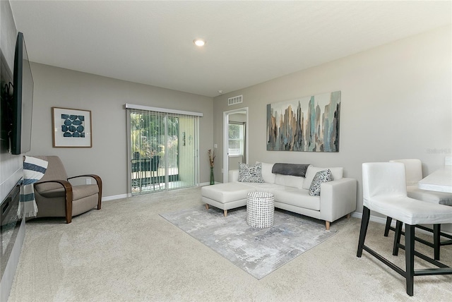 living area featuring visible vents, carpet floors, and baseboards