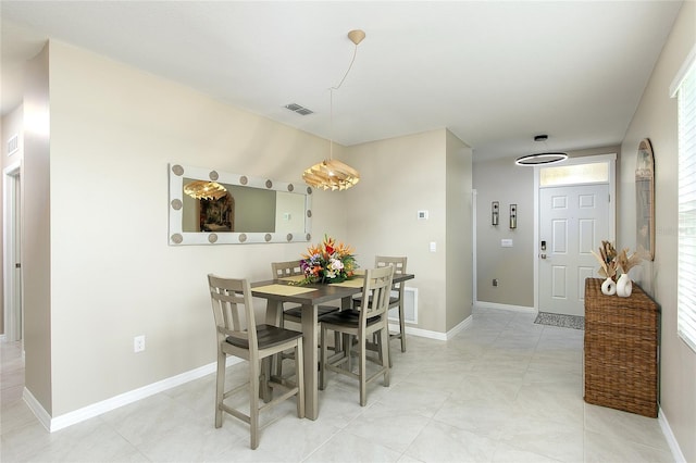 dining area featuring light tile patterned flooring, visible vents, and baseboards