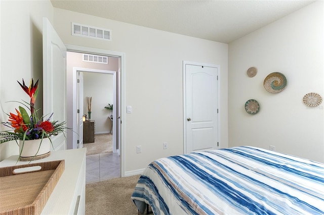 bedroom featuring visible vents, baseboards, and light colored carpet