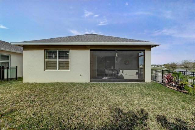 rear view of house with fence, roof with shingles, a yard, a sunroom, and stucco siding