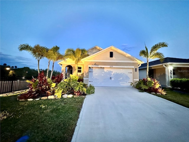 ranch-style house with an attached garage, concrete driveway, and fence