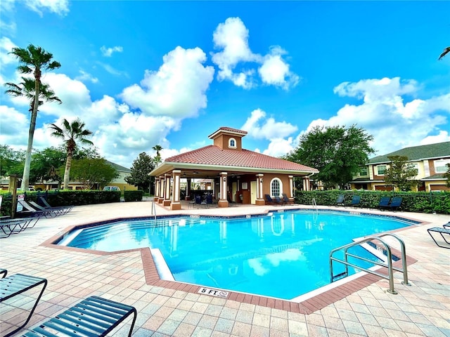 pool with a patio area and fence