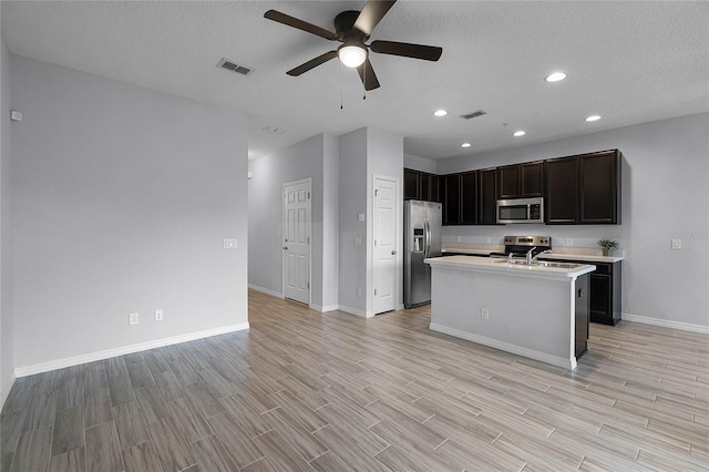 kitchen featuring light countertops, wood tiled floor, visible vents, and stainless steel appliances