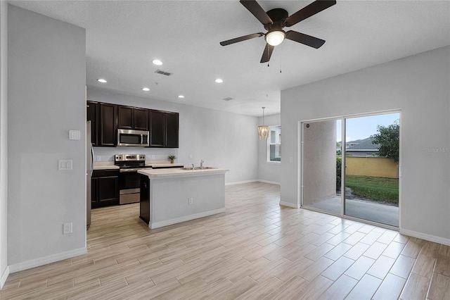 kitchen featuring visible vents, light wood-style flooring, a sink, stainless steel appliances, and light countertops