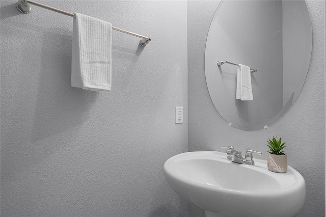 bathroom featuring a textured wall and a sink