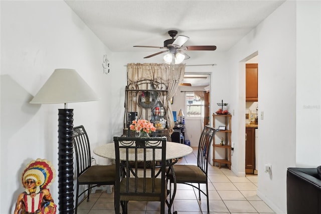 dining space with light tile patterned floors, baseboards, and ceiling fan