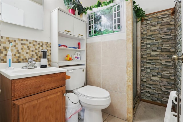 bathroom with toilet, tile walls, a stall shower, and vanity