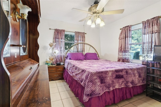 bedroom featuring light tile patterned floors, multiple windows, and a ceiling fan