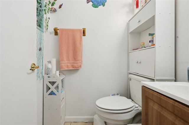 bathroom featuring toilet, vanity, and baseboards