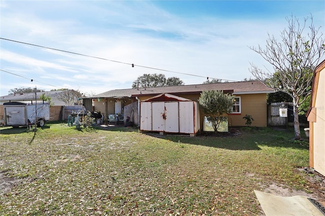 rear view of property featuring a storage unit, an outbuilding, a lawn, and fence