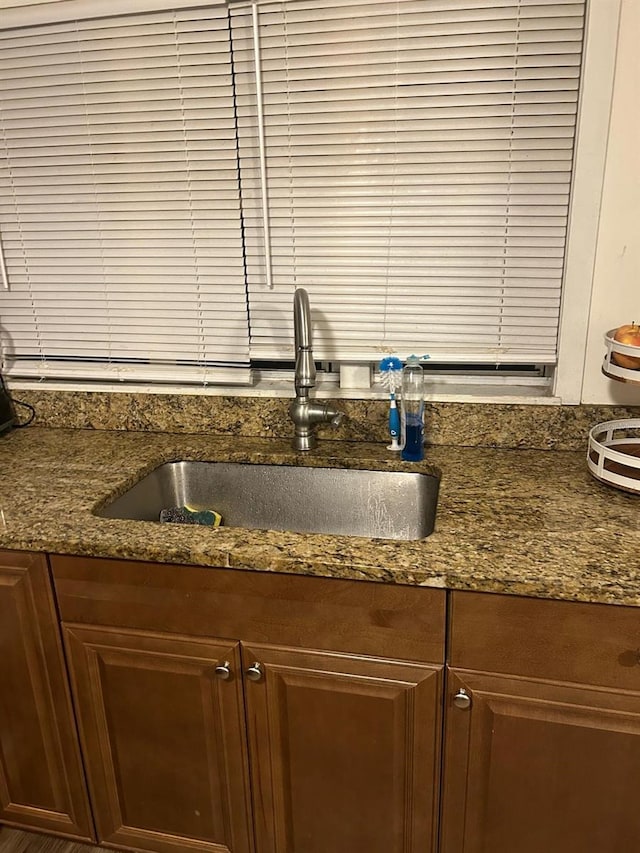 kitchen featuring dark stone countertops and a sink