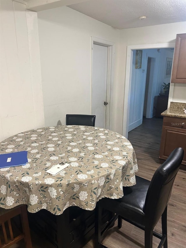 dining area with a textured ceiling and wood finished floors