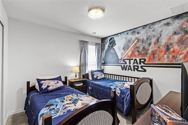 carpeted bedroom with baseboards and a textured ceiling