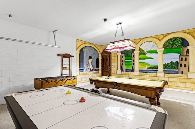 recreation room featuring speckled floor, concrete block wall, and billiards