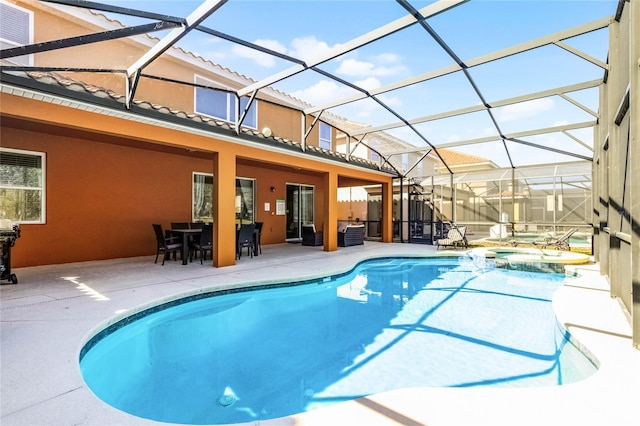 view of pool with a lanai, a pool with connected hot tub, outdoor dining area, and a patio