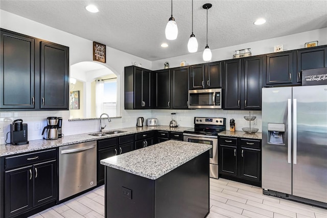 kitchen featuring a sink, stainless steel appliances, and dark cabinets