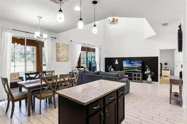 kitchen featuring a notable chandelier, visible vents, hanging light fixtures, and lofted ceiling