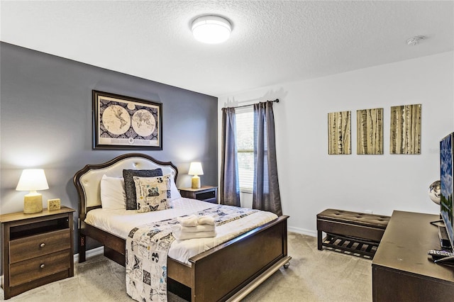 bedroom with baseboards, light colored carpet, and a textured ceiling