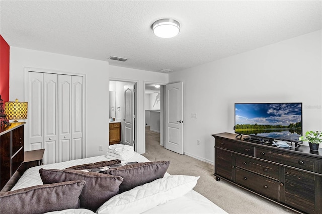 bedroom featuring light colored carpet, visible vents, a closet, and a textured ceiling