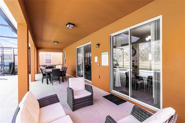 view of patio featuring glass enclosure, outdoor dining space, and outdoor lounge area