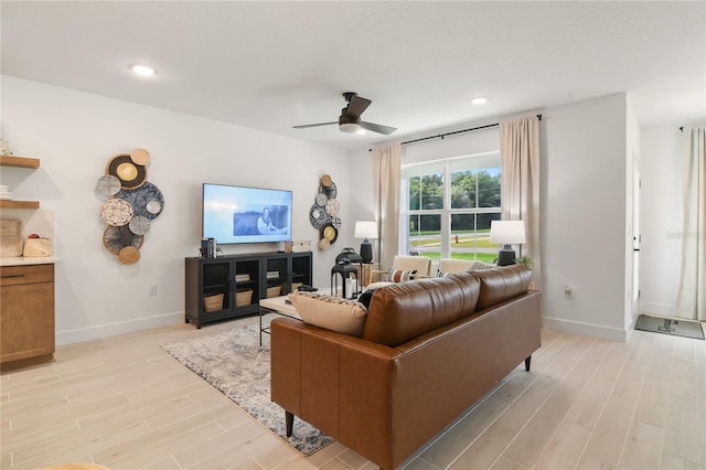 living area with recessed lighting, baseboards, a ceiling fan, and light wood finished floors