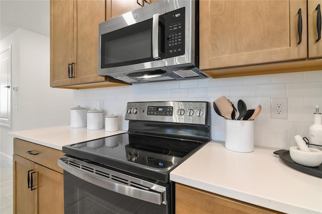 kitchen featuring decorative backsplash, appliances with stainless steel finishes, and light countertops